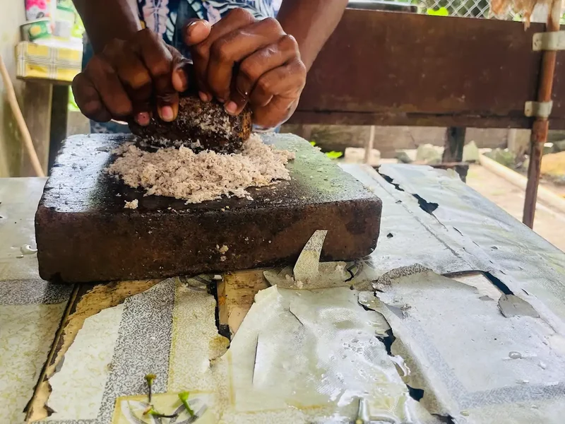 Hands grate ingredients over a wooden board during food preparation.